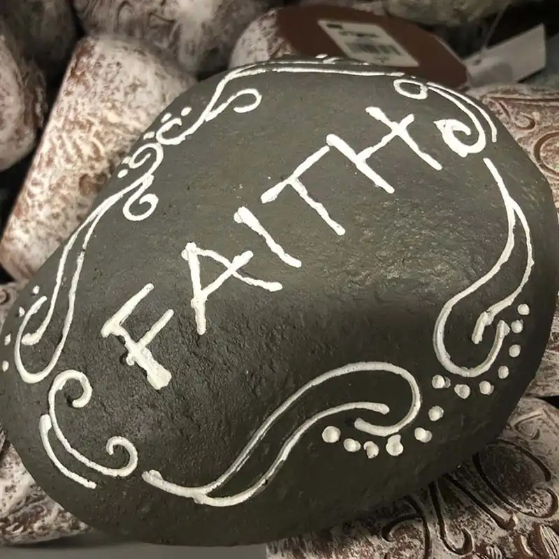 the word faith painted on a rock